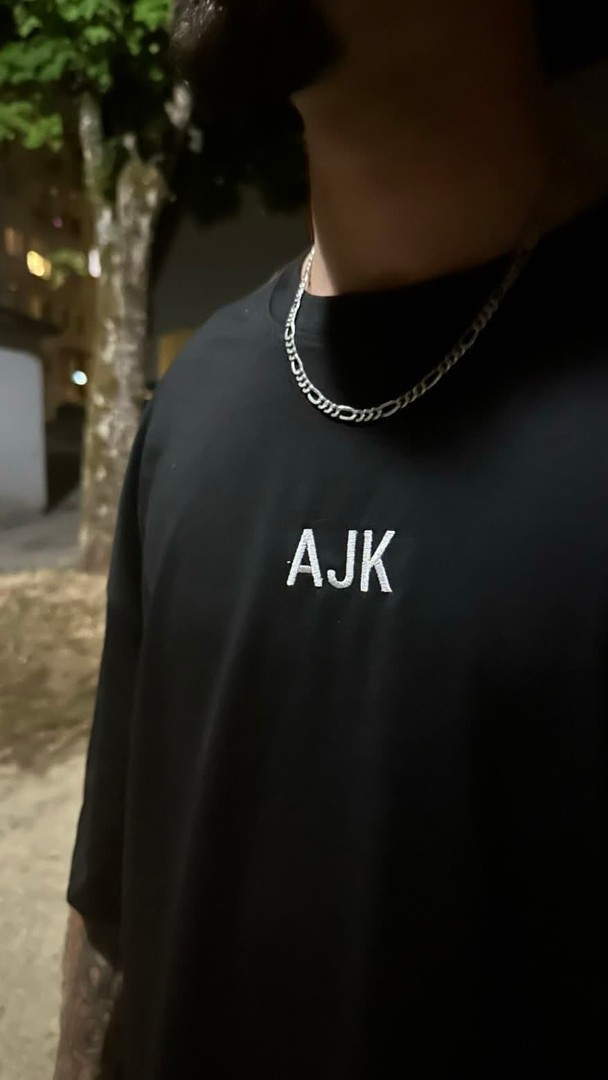 Broderie AJVEK blanche sur tee-shirt noir