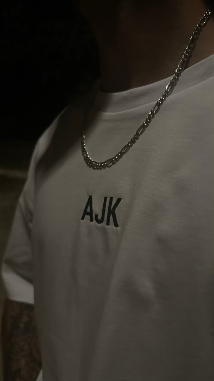Détail de la broderie AJVEK sur tee-shirt blanc